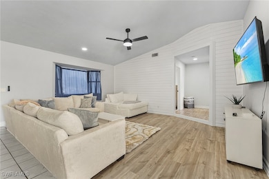 Living room featuring ceiling fan, lofted ceiling,