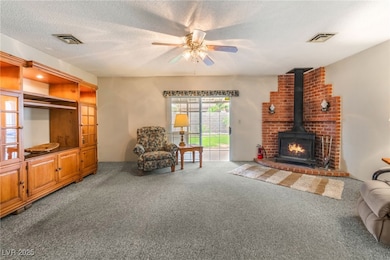 Living room with carpet floors, ceiling fan, a woo