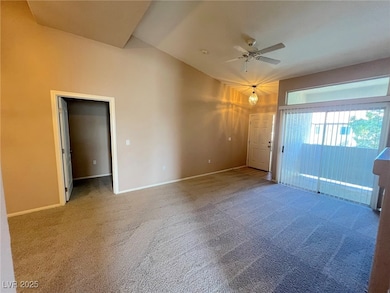 Empty room with carpet floors and a ceiling fan