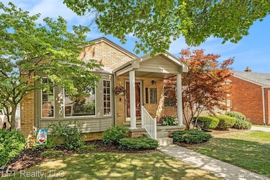 Bungalow-style home with a front yard, brick siding, and covered porch