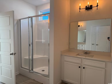 Bathroom featuring vanity and a shower with door