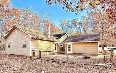 Back of house featuring roof with shingles