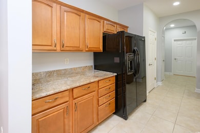 Kitchen with black fridge, arched walkways, light 