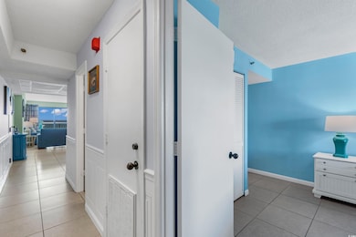 Hall with a textured ceiling, light tile patterned