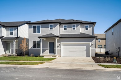 Traditional-style house featuring concrete driveway, roof with shingles, an attached garage, and a front lawn