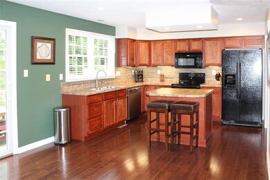 Kitchen with island, cherry cabinets and neutral b