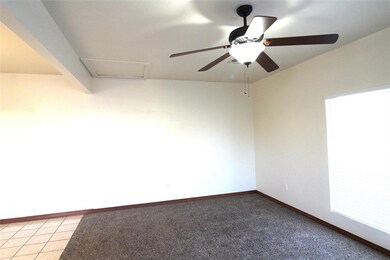 Carpeted spare room featuring ceiling fan
