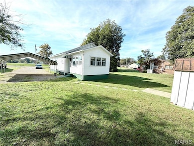 Back of home includes an enclosed sunroom/utility room.