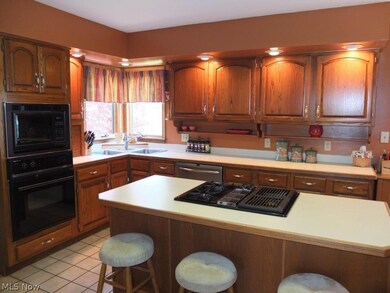 Fully applianced kitchen with island and breakfast bar.