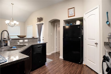 Kitchen featuring an inviting chandelier, black ap