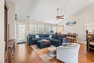 Living area with light wood-type flooring, ceiling fan, baseboards, and high vaulted ceiling