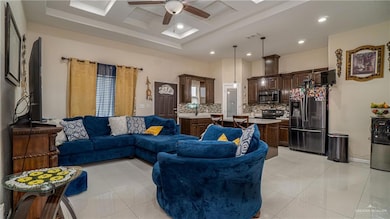 Living room with ceiling fan, recessed lighting, light tile patterned flooring, and a tray ceiling