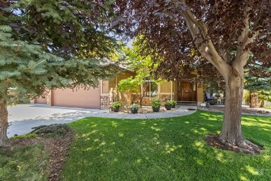 Obstructed view of property with concrete driveway, a front lawn, stone siding, stucco siding, and an attached garage