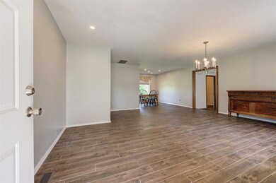 Spare room featuring a chandelier, dark wood-style flooring, baseboards, and recessed lighting