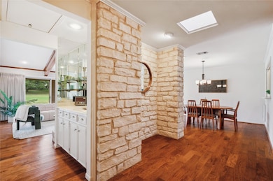 Hall with crown molding, visible vents, dark wood