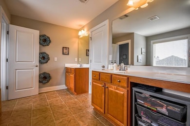 Bathroom featuring beverage cooler, vanity, tile patterned flooring, and baseboards