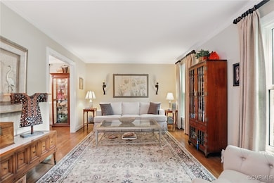 Living room with wood finished floors, crown moldi