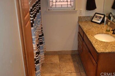 Full bath has travertine flooring and granite-topp
