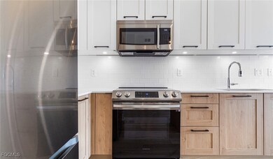 Kitchen featuring light countertops, tasteful backsplash, appliances with stainless steel finishes, and a sink