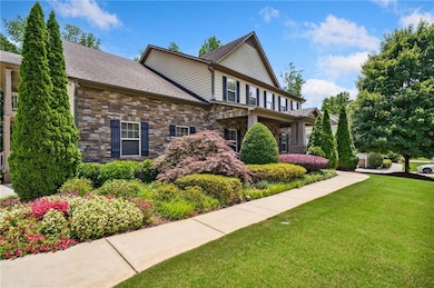 View of front of home with a front lawn and stone siding