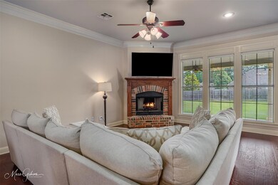 Living room with ceiling fan, a fireplace, dark ha