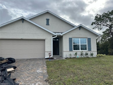 View of front facade with stucco siding, a front yard, and an attached garage