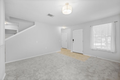 Empty room featuring carpet and baseboards