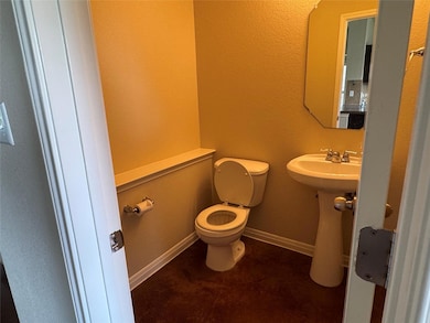 Half bath featuring toilet and baseboards