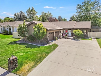 Ranch-style house with an attached garage, stone siding, concrete driveway, stucco siding, and a tiled roof