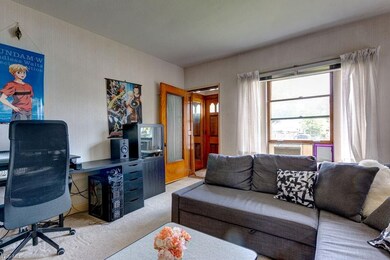 Downstairs front unit looking towards the entry way which has original tile and doors. Still in wonderful condition and there is hardwood under the carpets.