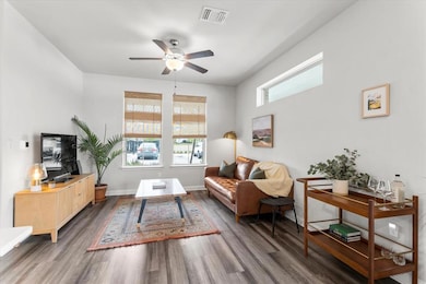 Living area with ceiling fan and wood finished fl