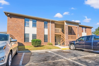 View of property featuring stairway and uncovered parking