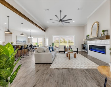 Living room with a ceiling fan, a glass covered fi