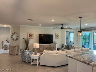 Tiled living room with ceiling fan and crown moldi