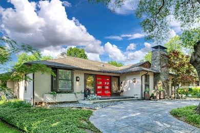 View of front of house featuring a chimney, brick siding, roof with shingles, and french doors