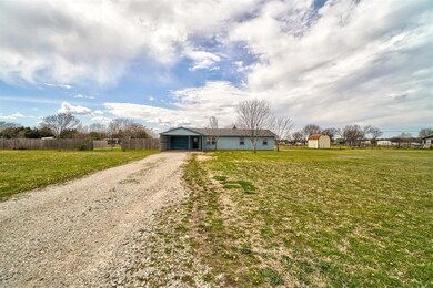 Front of home showing driveway and large front yar