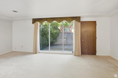 Large family room with lots of light and windows looking out to front patio