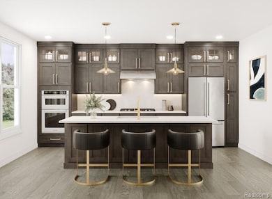 Kitchen featuring a kitchen breakfast bar, an island with sink, stainless steel appliances, dark brown cabinets, and recessed lighting