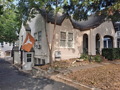 View of front of home with stucco siding, covered
