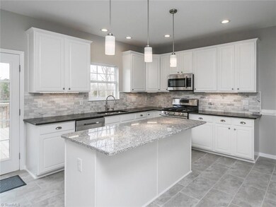 Kitchen with granite, tile backsplash, recessed lighting and updating light fixtures over your roomy kitchen island.  Over the range microwave gives you even more counter space.  Tile flooring.  Easy access to deck for grilling and outdoor entertainment.