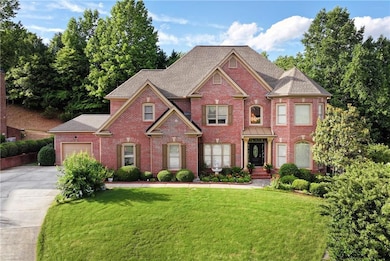 Colonial house with concrete driveway, brick siding, a garage, and a front yard