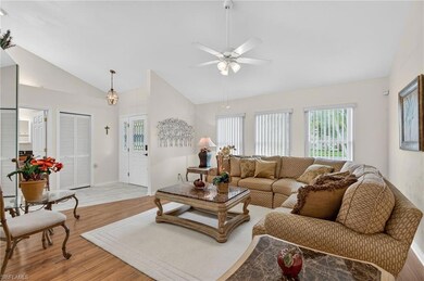 Living area with light wood-style flooring, vaulted ceiling, and a ceiling fan