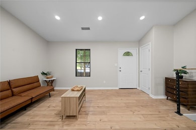 Foyer entrance with light wood finished floors, baseboards, and recessed lighting