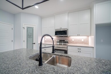 Kitchen featuring light stone countertops, stainle