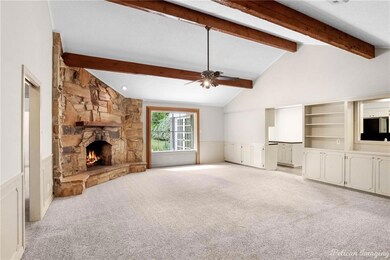 Large den with a vaulted ceiling, fireplace and bu