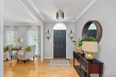 Hardwood floored entryway featuring crown molding
