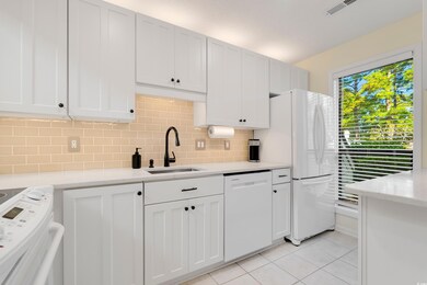 Kitchen featuring white cabinetry, Ruvati sink, ba