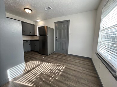Here we see the charming dining area and a back door for easy outdoor access. Notice the natural lighting that comes in from the windows.