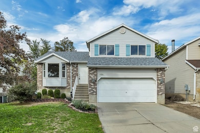 View of front of house with driveway, brick siding, an attached garage, a front lawn, and roof with shingles