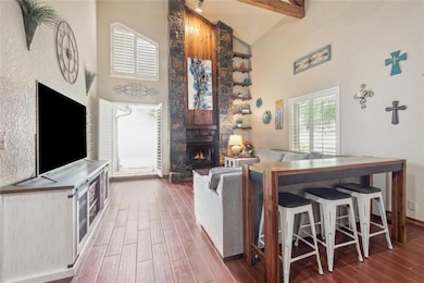 Another view of living area with that AMAZING stone fireplace, lots of natural light with plantation shutters for privacy